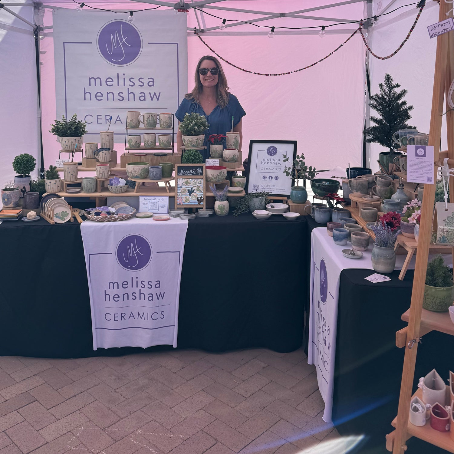 Melissa Henshaw Ceramics booth at a local market with products and branding.